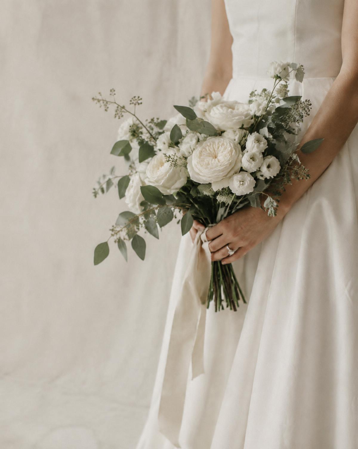 Bride holding a bouquet of white garden roses